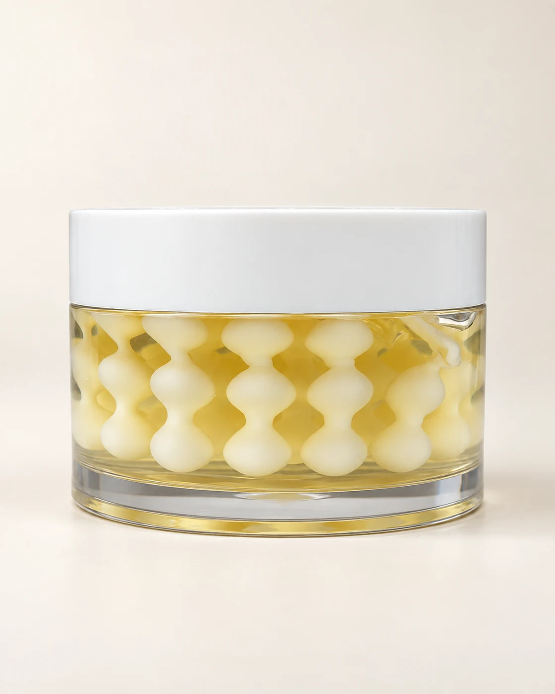 White cream pearls in golden liquid, from supplied footage; AI-retouched still